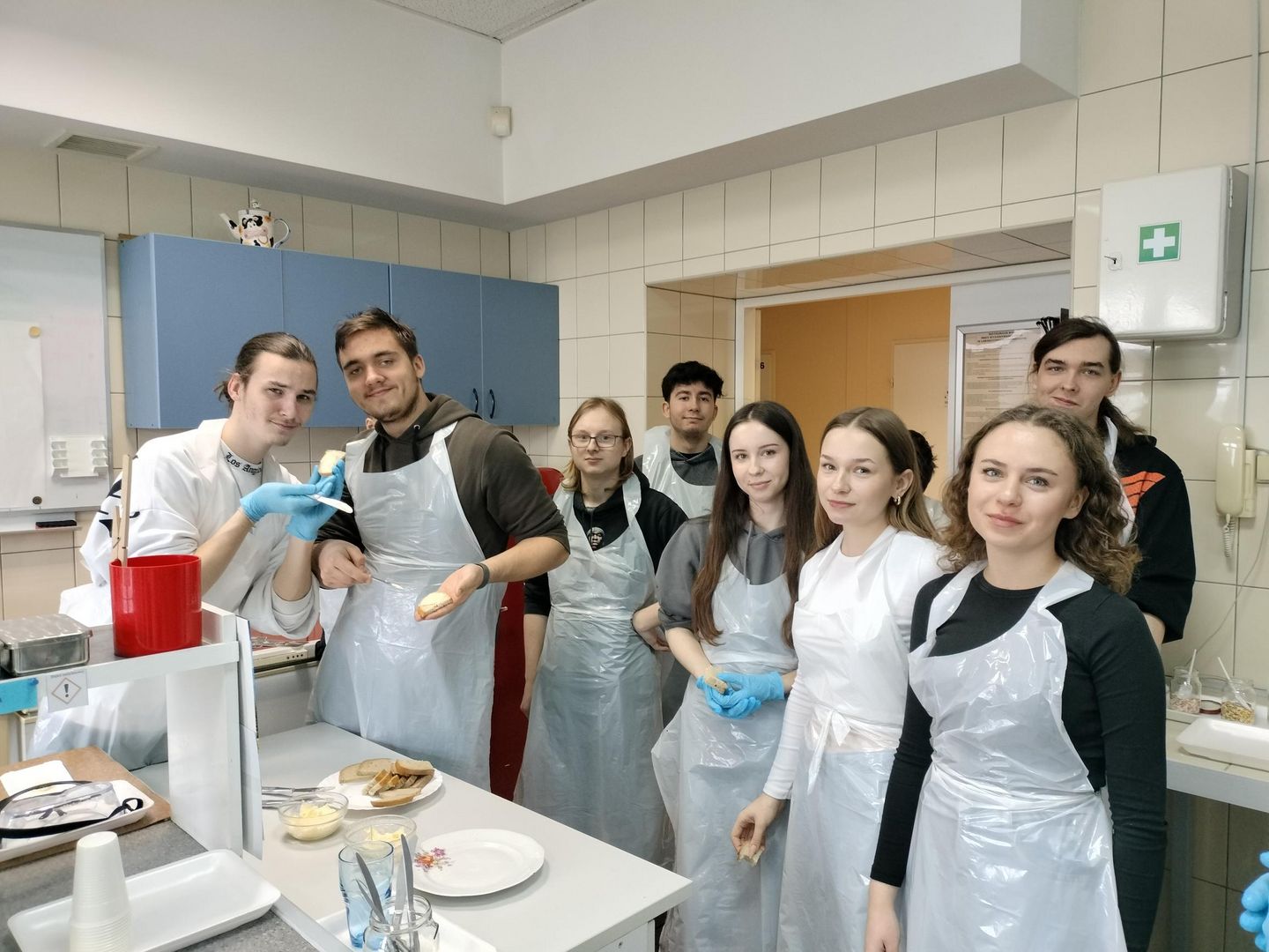 Grupa młodzieży w laboratorium podczas degustacji masełka